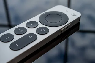 Pormenor de um comando Apple TV prateado.
